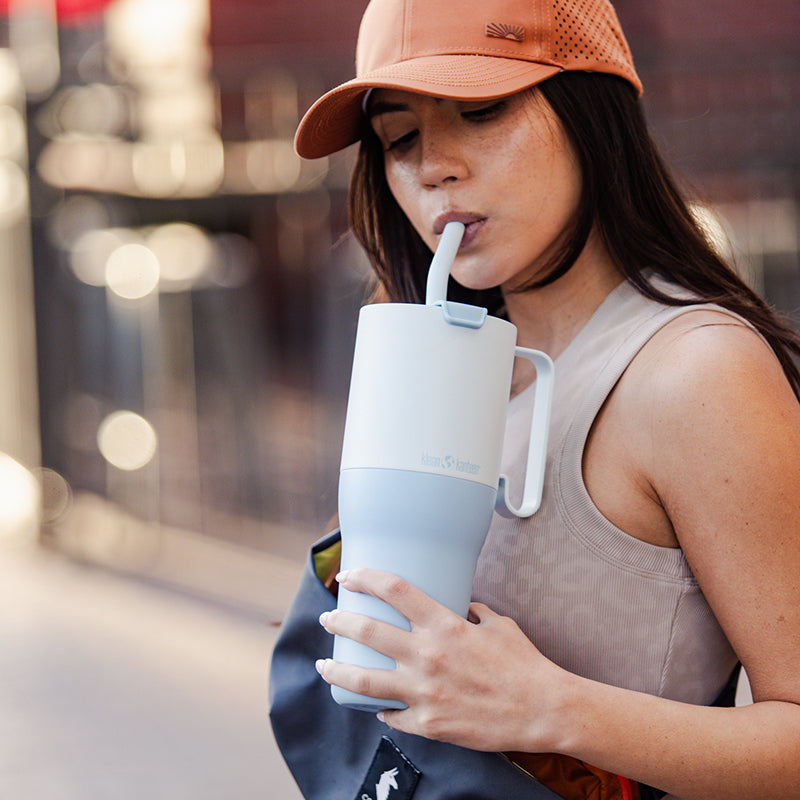 Woman drinking from straw in tumbler