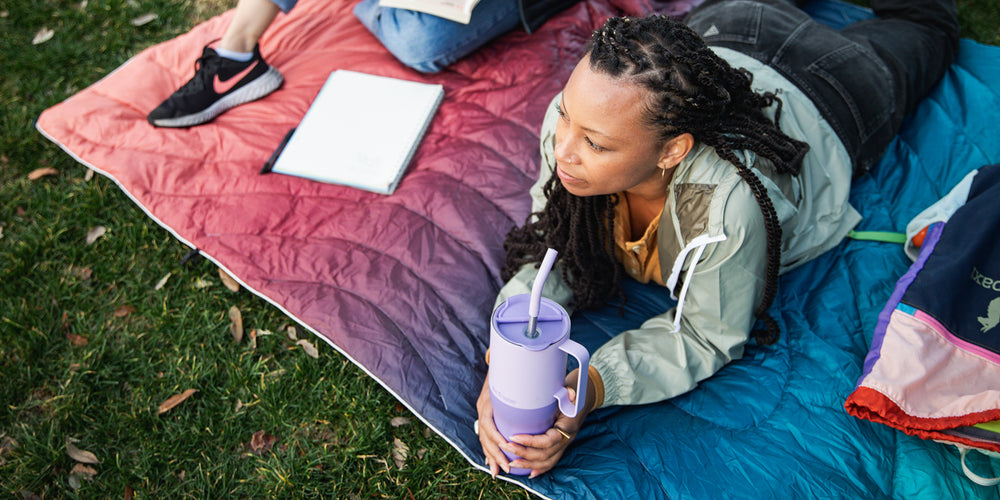 Woman on blanket at park with 36oz Tumbler