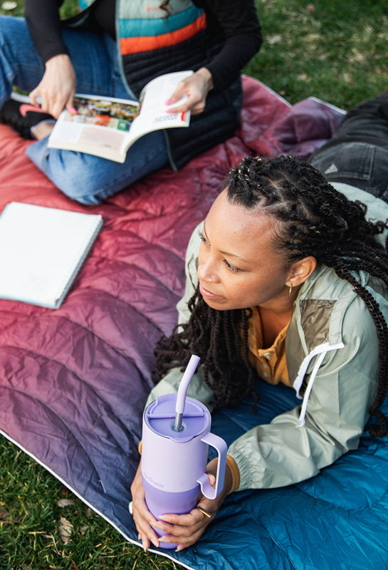 Woman on blanket at park with 36oz Tumbler