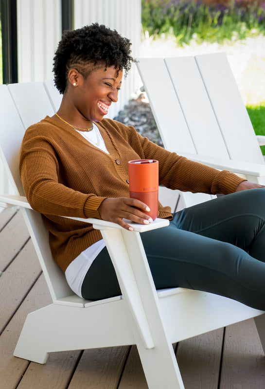 Woman sitting on porch with tumbler