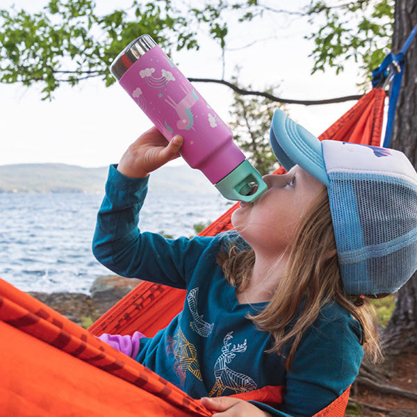 Girl in hammock drinking from water bottle