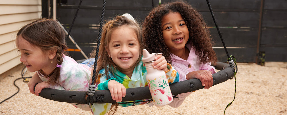 Girls in swing with sippy bottle