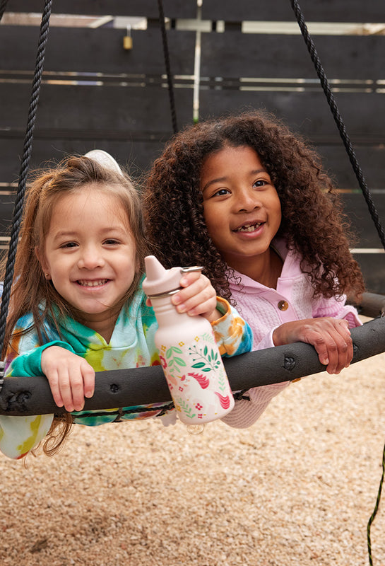 Girls in swing with sippy bottle